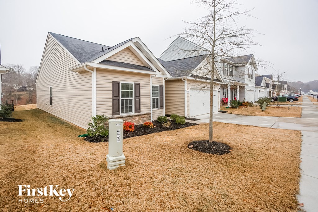 three homes in a row on a street with a tree in the front yard