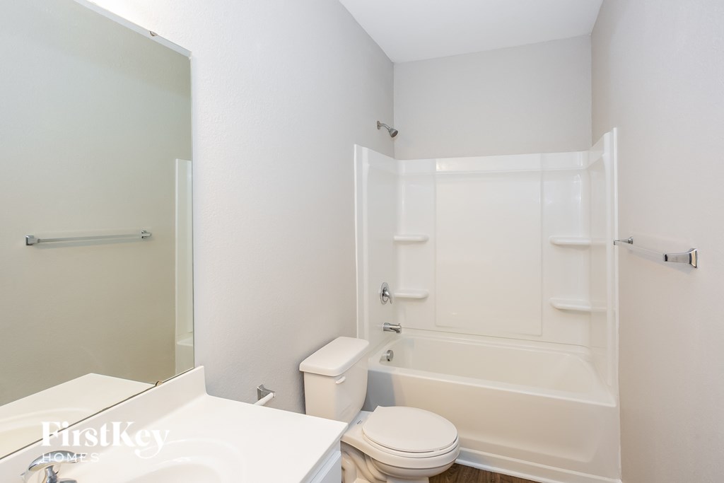 a white bathroom with a toilet and a tub and a sink