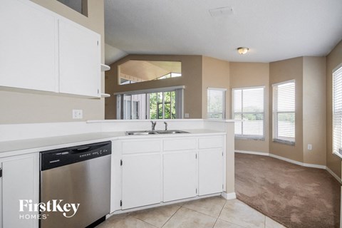 A kitchen with white cabinets and a stainless steel dishwasher.