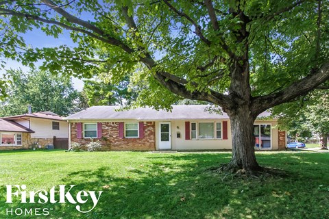 A tree in front of a house with the words "FirstKey Homes" on the bottom left.