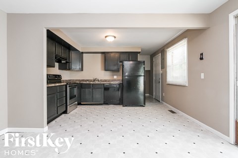 A kitchen with black appliances and a black refrigerator.