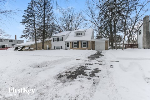 a house with snow on the ground and a driveway