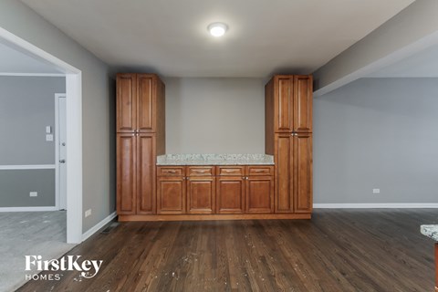 a kitchen with wooden cabinets and a counter top in a room with wood flooring