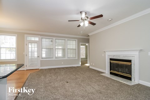 a living room with a fireplace and a ceiling fan