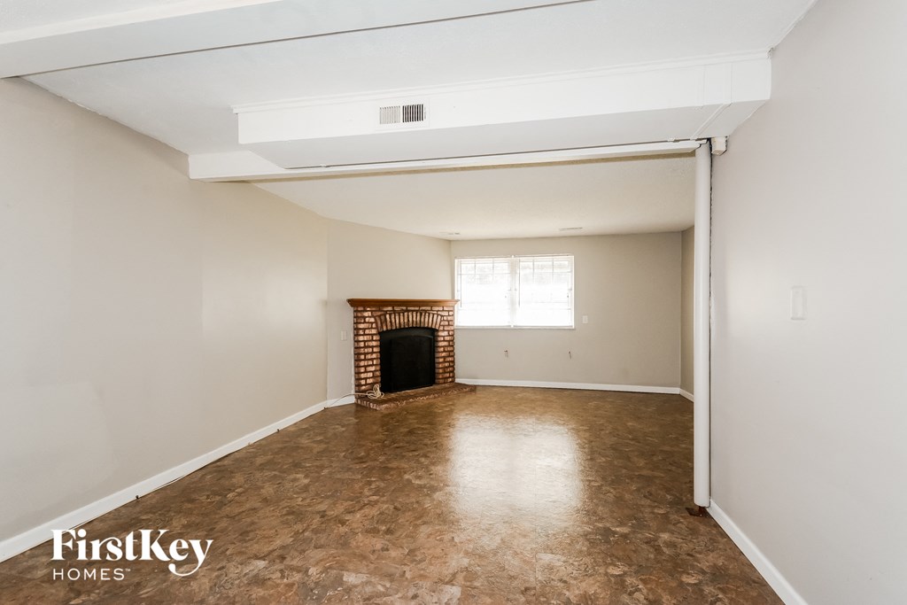 a living room with white walls and a fireplace