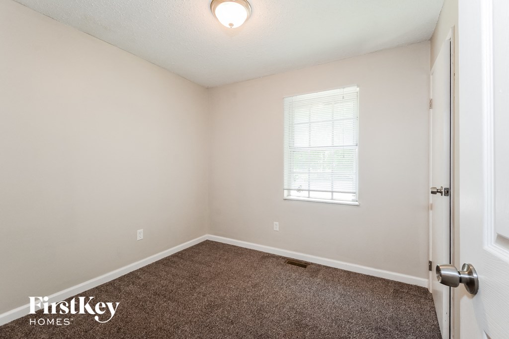 a bedroom with a carpeted floor and a window