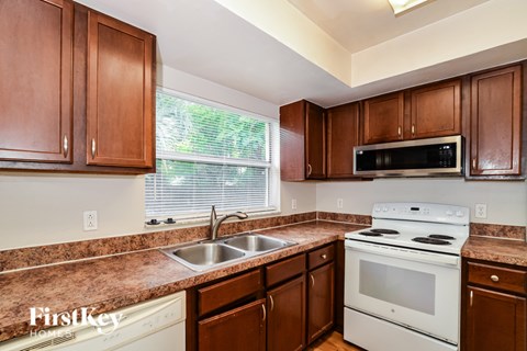 A kitchen with brown cabinets and white appliances.