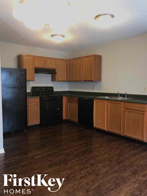 A kitchen with wooden cabinets and black appliances.
