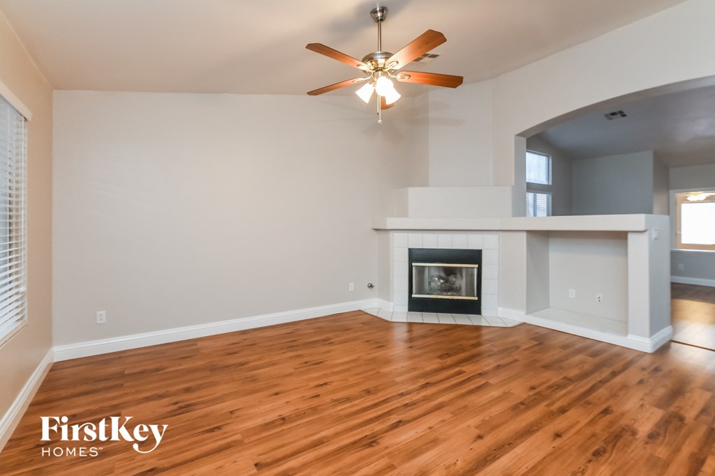 A room with a fireplace and a ceiling fan.