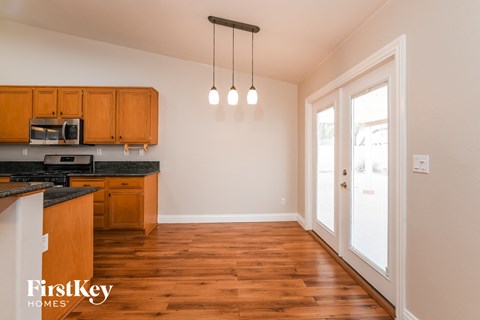 A kitchen with wooden cabinets and a black countertop.