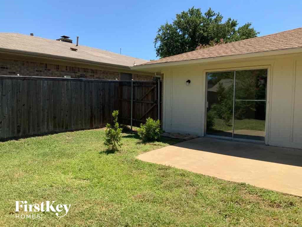 a small yard in front of a house with a patio