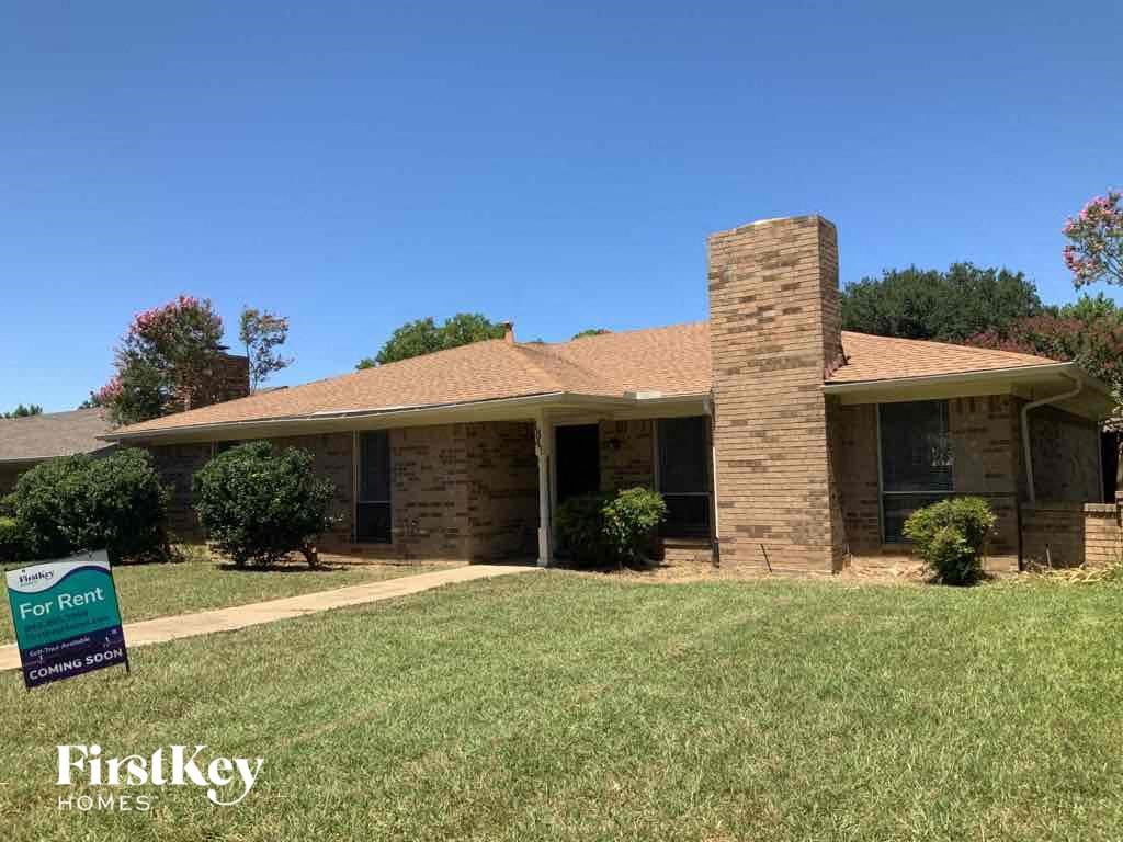 a brick house with a yard and a sign for hickory homes