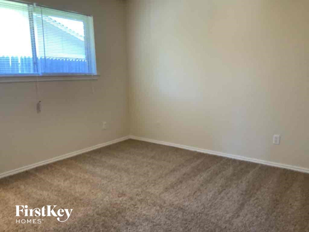 an empty room with carpet and a window