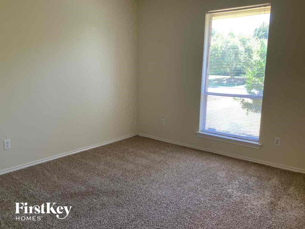 an empty room with a window and carpet