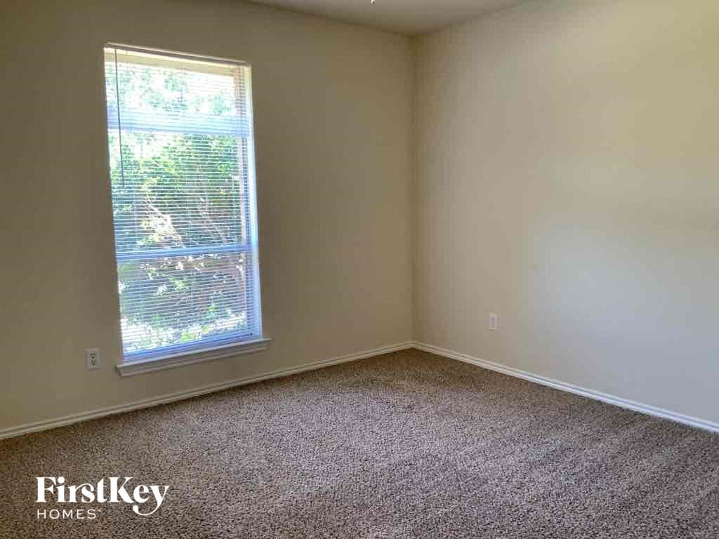 an empty room with a window and carpet