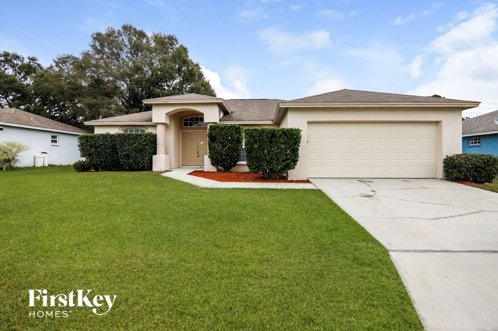a white house with a lawn and a driveway