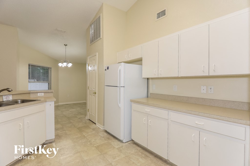 a kitchen with white cabinets and a white refrigerator