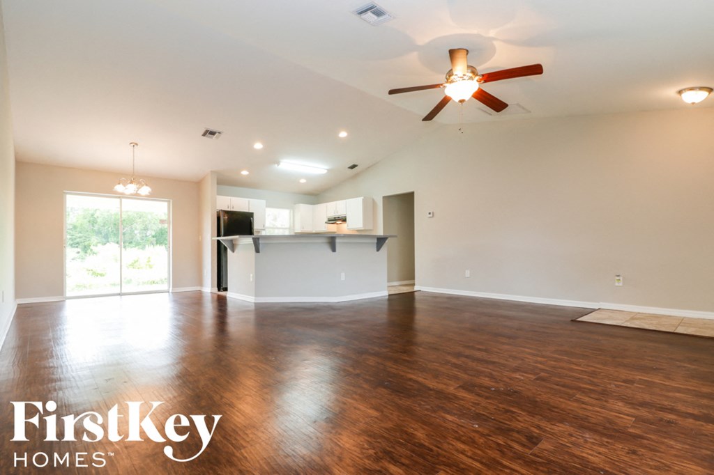 A spacious room with a ceiling fan and wooden flooring.