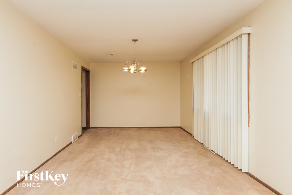 Empty room with a chandelier hanging from the ceiling.