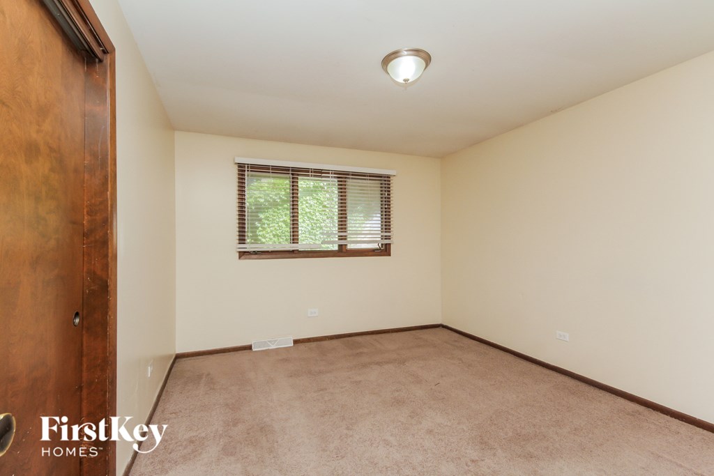 A room with a window and a wooden door.