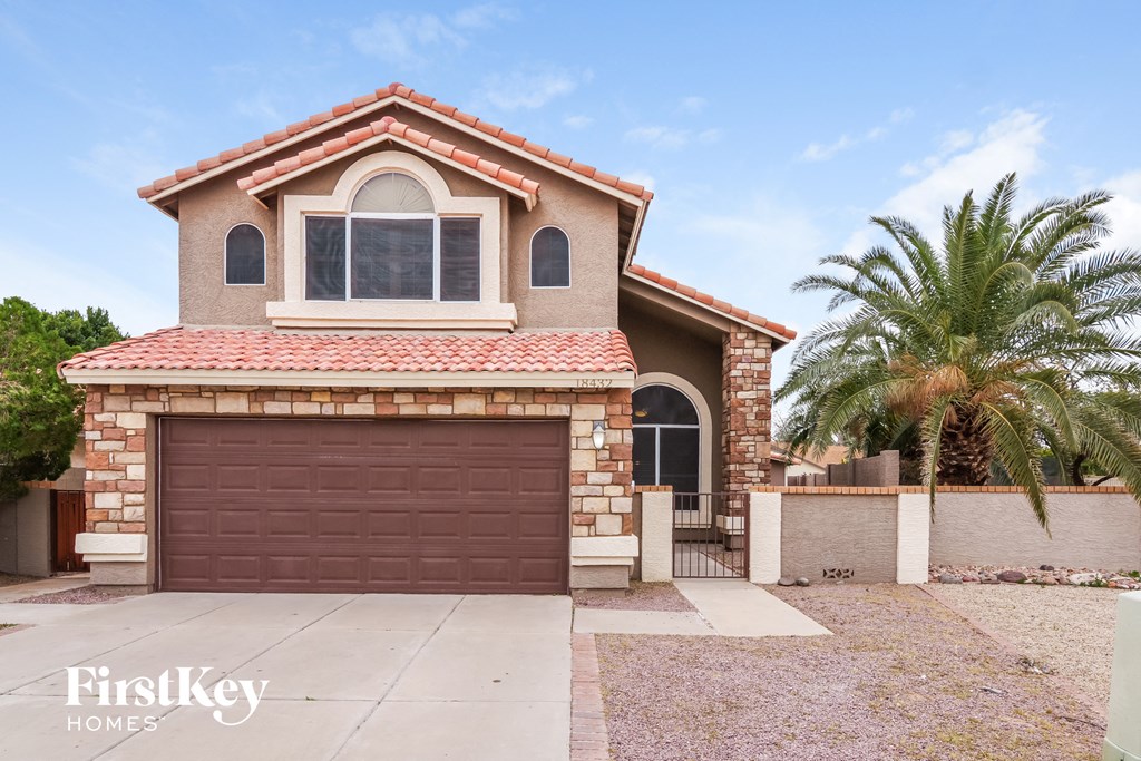 a house with a garage and a palm tree