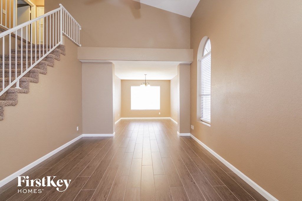 an empty empty living room with a staircase and a window