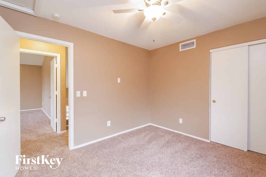 a bedroom with carpet and a ceiling fan