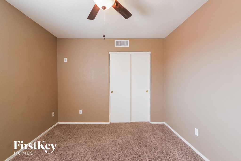 a empty room with a ceiling fan and a closet
