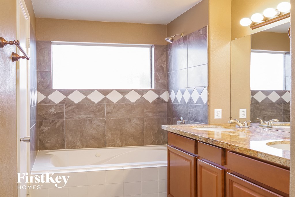 a bathroom with a tub and a sink and a mirror