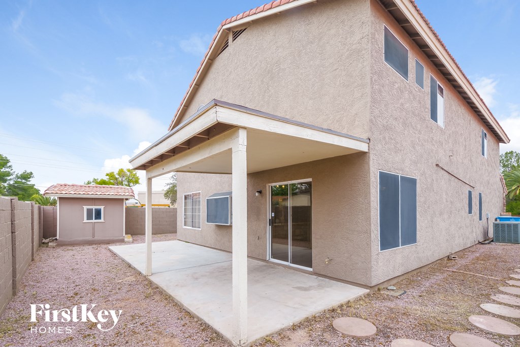 a beige house with a patio and a sidewalk