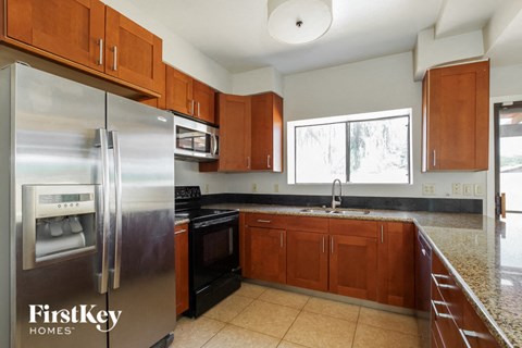 A kitchen with a refrigerator that says FirstKey Homes.