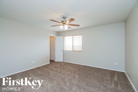 a bedroom with a ceiling fan and a white door