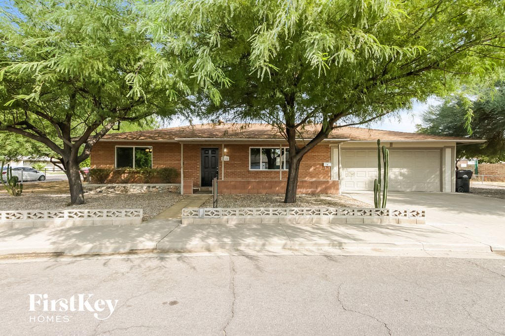 a house with a driveway and trees in front of it
