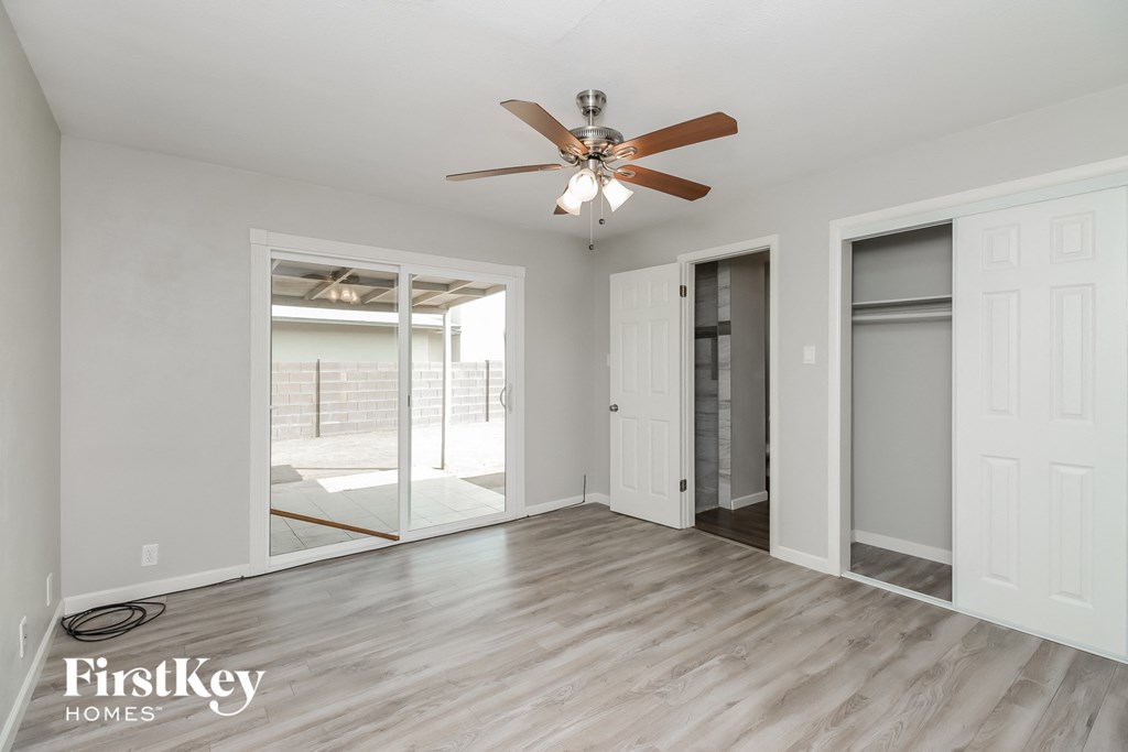 a living room with a ceiling fan and sliding glass doors