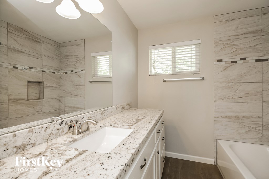 a bathroom with marble counter tops and a shower and sink