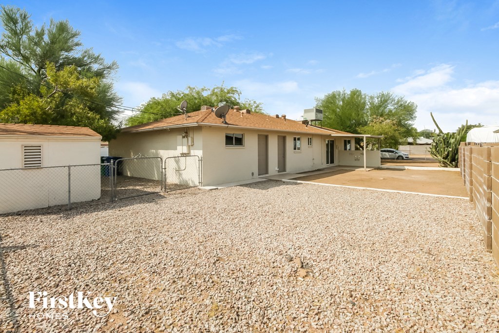a home with a gravel driveway and a white house
