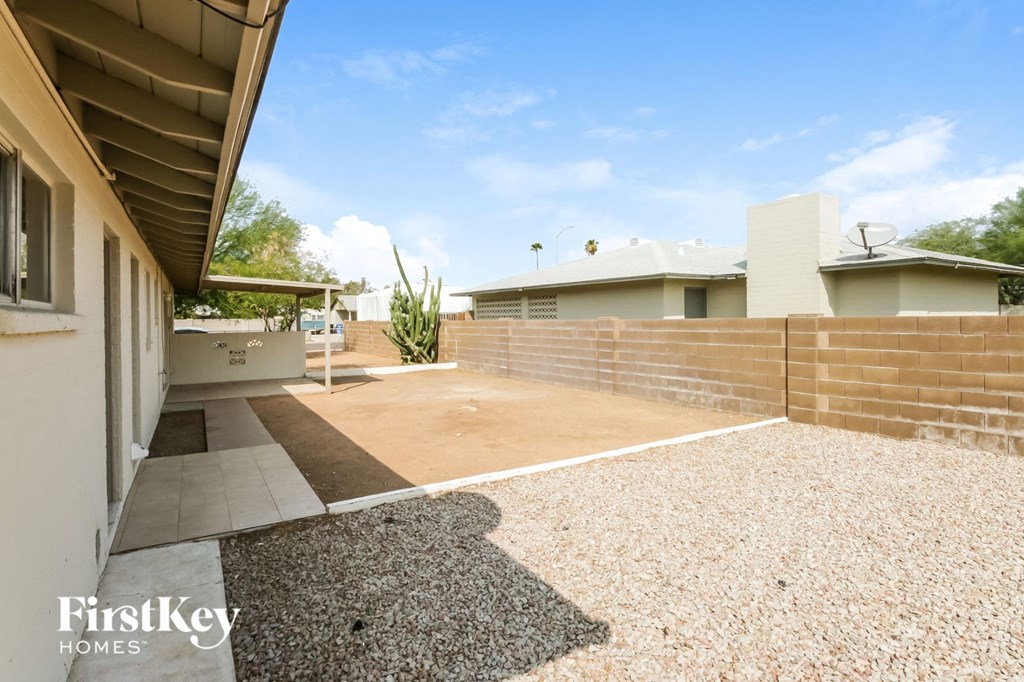 a yard with a brick fence and a house
