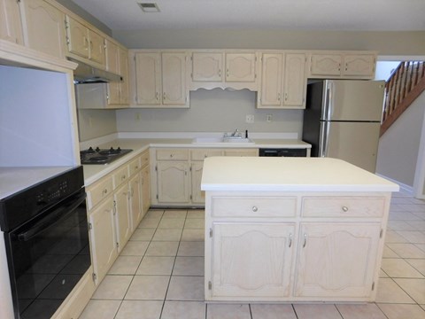 A kitchen with white cabinets and appliances.
