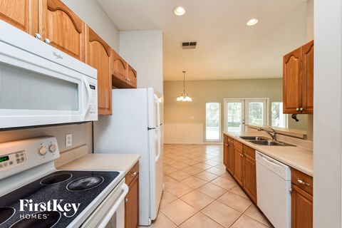 a kitchen with wood cabinets and white appliances and a sink