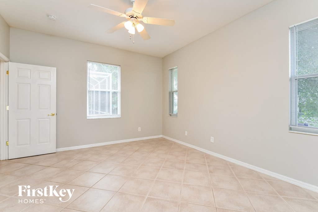 an empty room with a white door and a ceiling fan