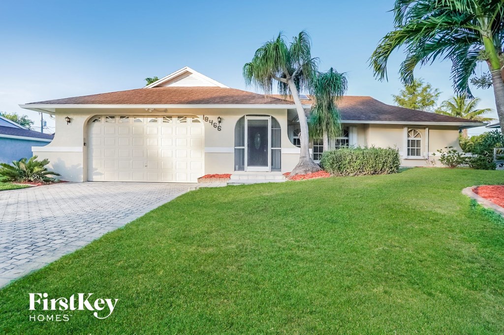 A house with a brown roof and a garage door is for sale.