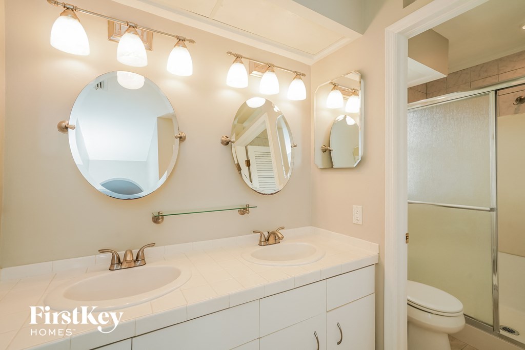 A bathroom with a white sink and a mirror above it.