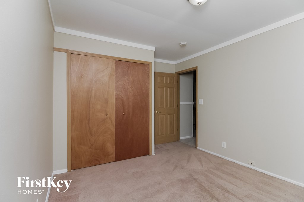 a bedroom with a closet and a door to a hallway