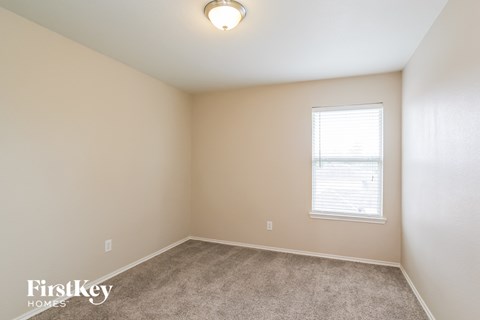 a bedroom with a carpeted floor and a window