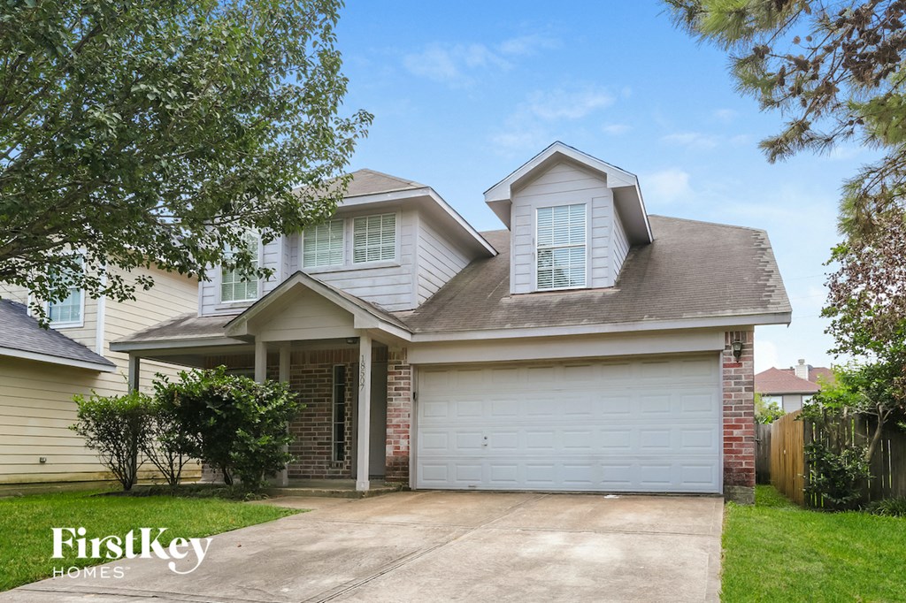 the front of a house with a white garage door