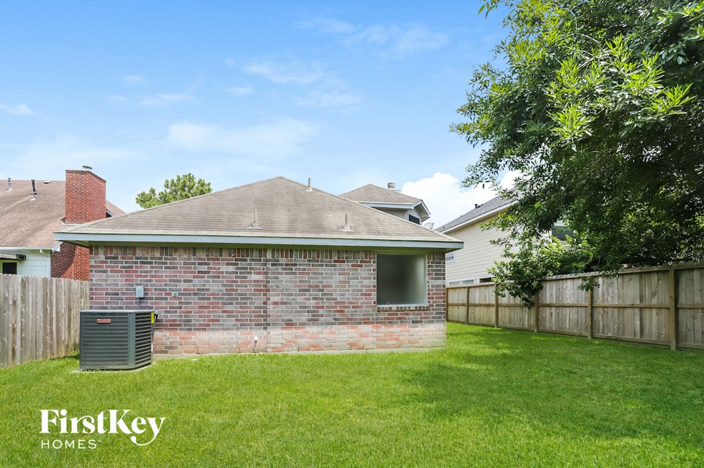 the backyard of a brick house with a yard and a heater