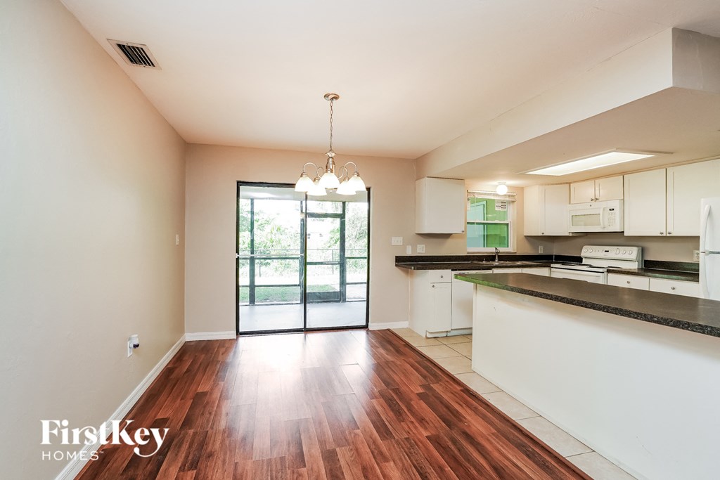 an open kitchen and living room with a large sliding glass door to the patio