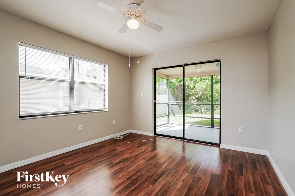 an empty living room with wood floors and a sliding glass door