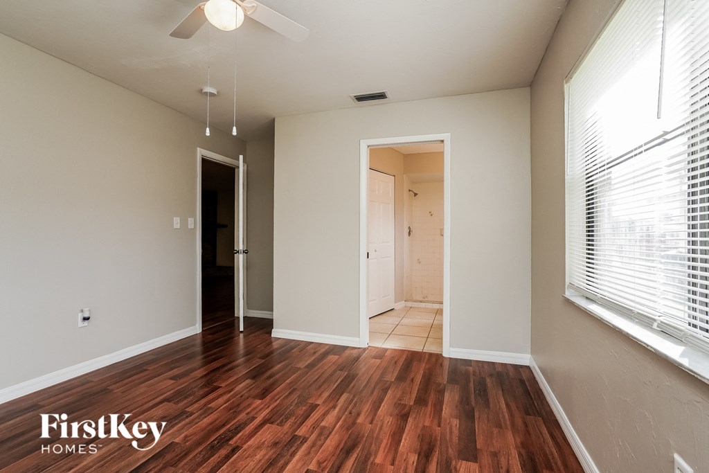 an empty living room with wood flooring and a large window
