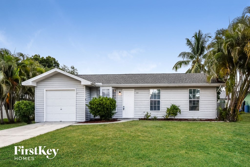 A house with a garage and a driveway is for sale.